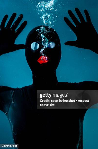 latex doll under water. - gimp mask stock pictures, royalty-free photos & images