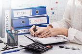 Person accounting incomes and expenses of a company, calculating taxes, concept of work in accountant department