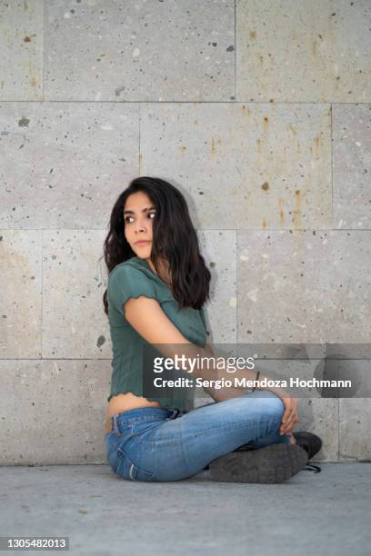 young latino woman sitting cross-legged on the floor in mexico city, mexico - fashion woman floor cross legged stock-fotos und bilder