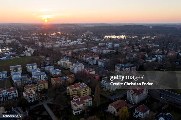 In this aerial view from a drone houses and residential buildings stand next to the Glienicke Bridge at sunset during the novel coronavirus pandemic...