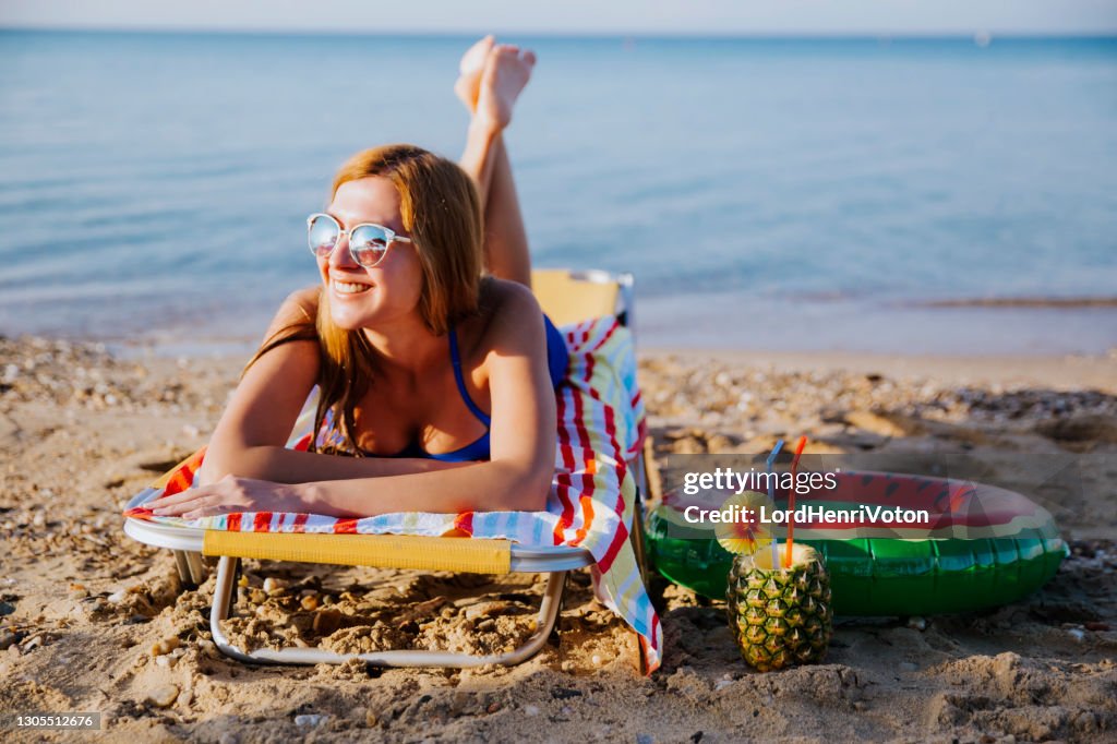 Giovane donna che si rilassa sulla spiaggia