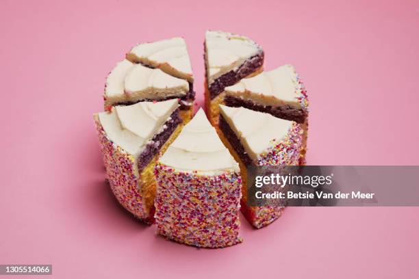 birtday rainbow cake cut in pieces on pink background. - fatia de bolo - fotografias e filmes do acervo