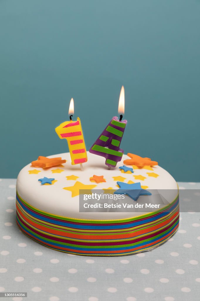 Birthday cake with number 14 candles burning on top.