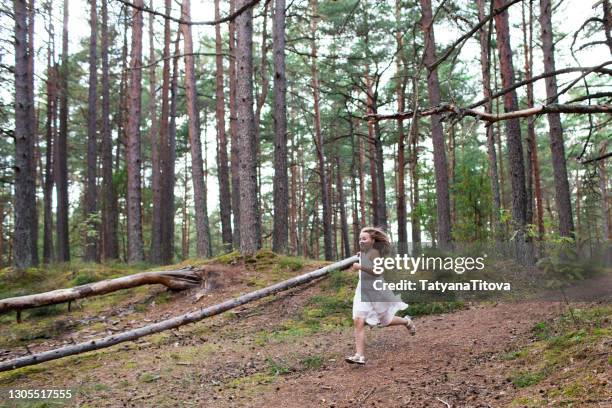 a girl in a white dress runs through the forest - latvia forest stock pictures, royalty-free photos & images