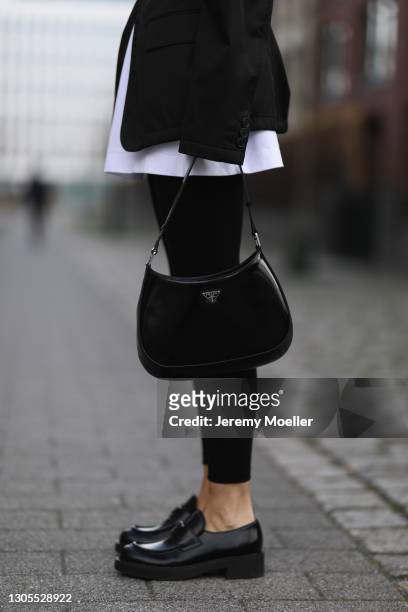 Kathrin Bommann wearing Prada jacket and loafer, Vival white shirt, Calzedonia black leggings and Prada Cleo bag on February 27, 2021 in Dusseldorf,...