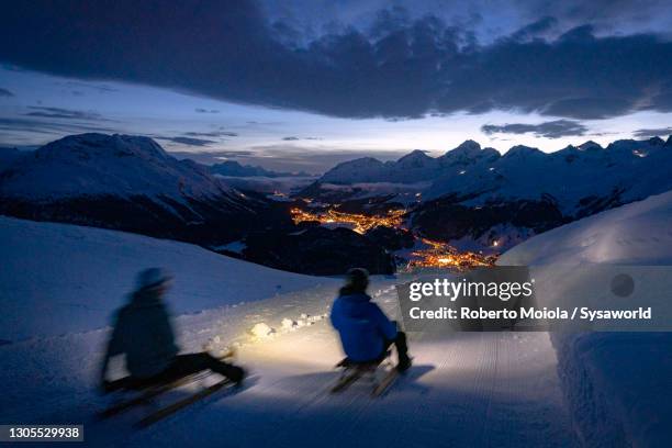 tourists sledding on the snow, muottas muragl, switzerland - sledge stock-fotos und bilder