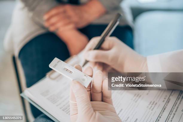 doctor testing patient using rapid test device for covid-19. - positive emotion stock pictures, royalty-free photos & images