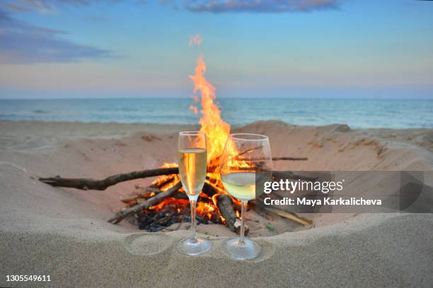 white whine and champagne glass by a campfire at the sea - fire escape fotografías e imágenes de stock