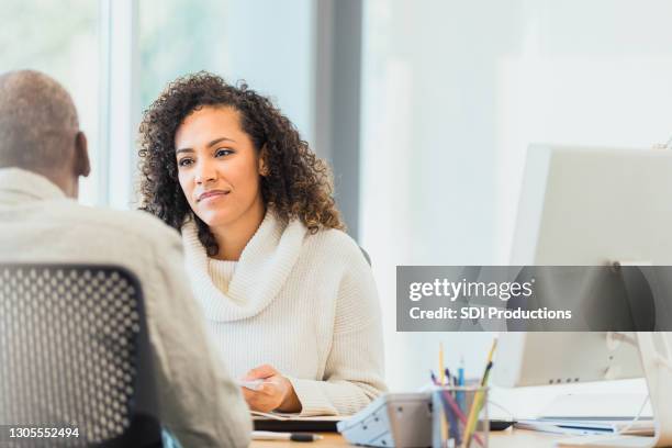 während unkenntlich männliche kundin spricht, hört bankerin zu - bank manager with client stock-fotos und bilder