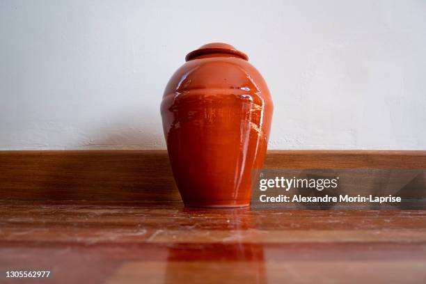 orange urn leaning against the white wall - ash 個照片及圖片檔