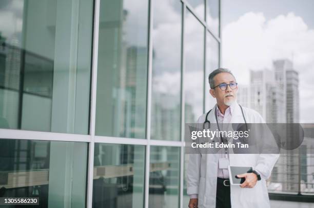 asian chinese male doctor walking towards his office - malaysian people stock pictures, royalty-free photos & images