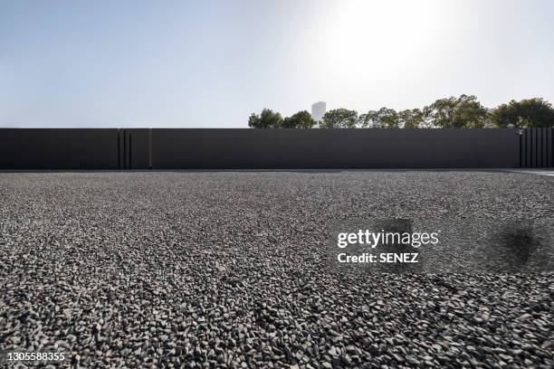 empty gravel parking lot - steinboden stock-fotos und bilder