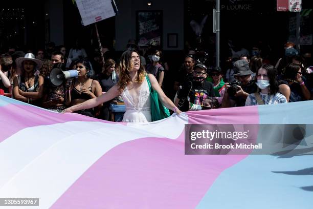 Protesters gather ahead of the Sydney Gay and Lesbian Mardi Gras parade as they campaign for LGBTQI rights in Taylor Square next to a banner with the...