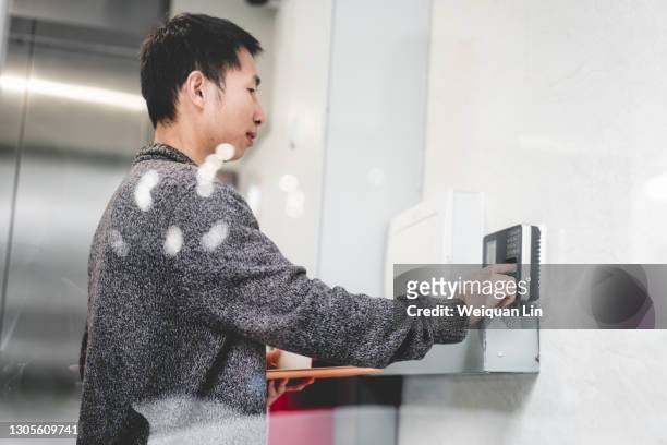 asian man signing in on attendance machine - time card stock pictures, royalty-free photos & images