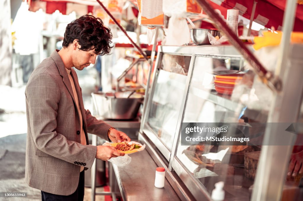 Man garbing quick lunch from food kiosk