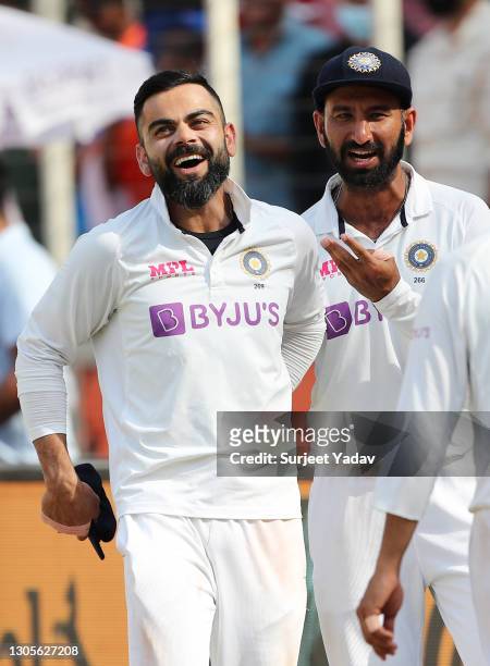 Virat Kohli and Cheteshwar Pujara of India celebrate victory after Day Three of the 4th Test Match between India and England at the Narendra Modi...