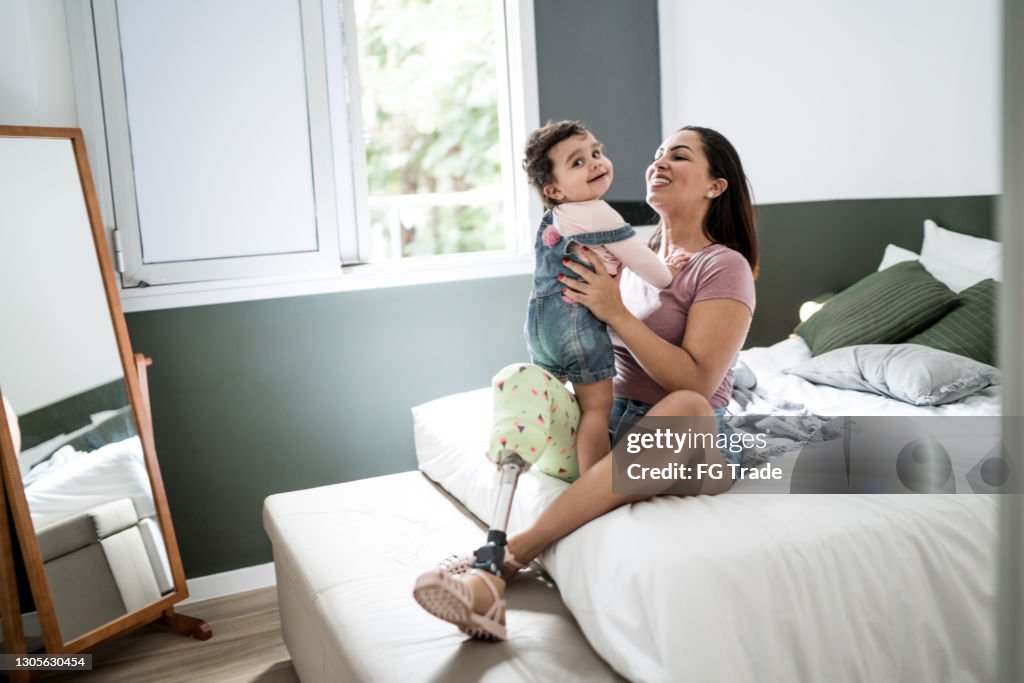 Disability mother playing with baby girl at home