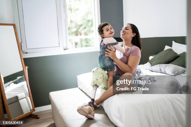 disability mother playing with baby girl at home - amputee woman imagens e fotografias de stock