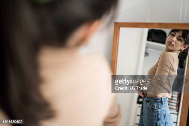jeune femme obtenant habillé devant un miroir à la maison - jeans outfit photos et images de collection