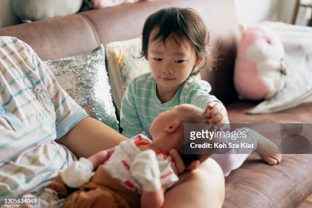 new asian sister welcoming her brother with affection and love - sibling stock pictures, royalty-free photos & images