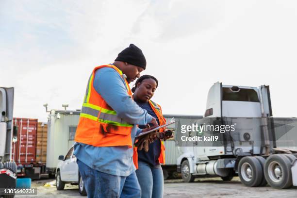 two workers at freight company talking,, with clipboard - trucker stock pictures, royalty-free photos & images