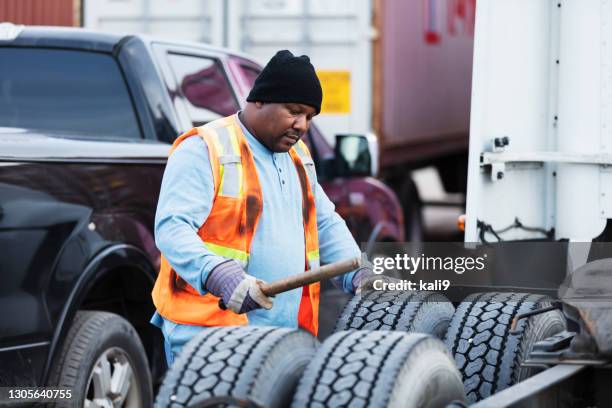 camionista che controlla pneumatici per una corretta pressione dell'aria - air vehicle foto e immagini stock