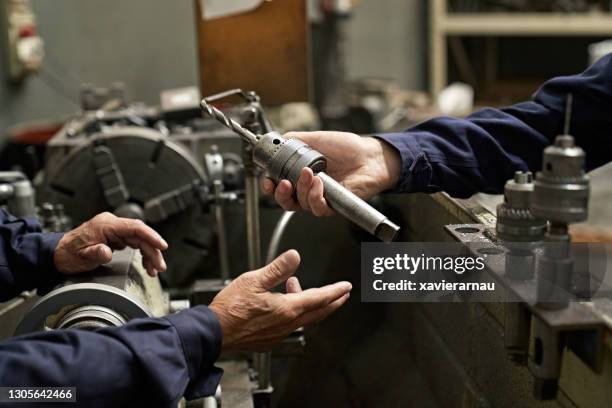 male metal worker sharing drill bit - pesca de lançamento imagens e fotografias de stock