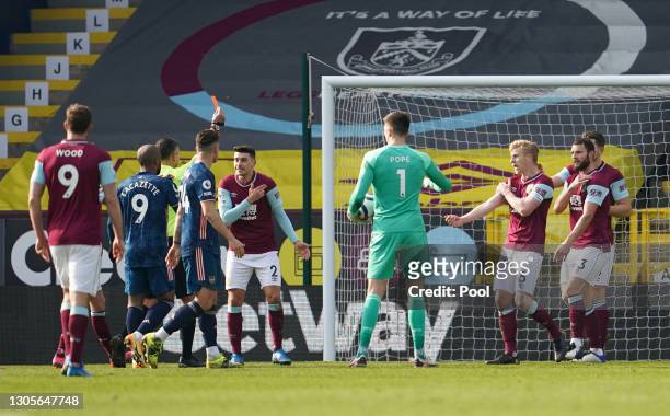 Referee Andre Marriner awards Erik Pieters of Burnley a red card, following a potential hand ball inside the penalty area, which is later over turned...