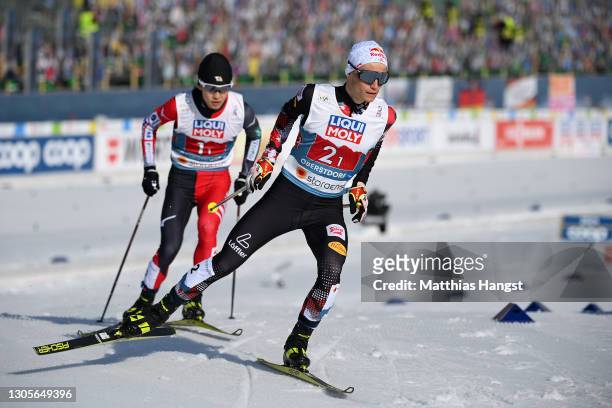 Johannes Lamparter of Austria and Akito Watabe of Japan compete in the cross-country leg during the Men's Nordic Combined Team HS137/4x7.5 Km at the...