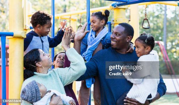 jong gezin met vijf kinderen op speelplaats, high-five - black man high 5 stockfoto's en -beelden