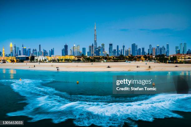 dubai panoramische oriëntatiepunthorizonmening met het strand van jumeirah op de voorgrond bij schemer - dubai jumeirah beach stockfoto's en -beelden