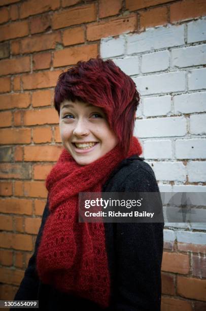 happy teenage girl standing in front of a brick wall - punk girl stock pictures, royalty-free photos & images