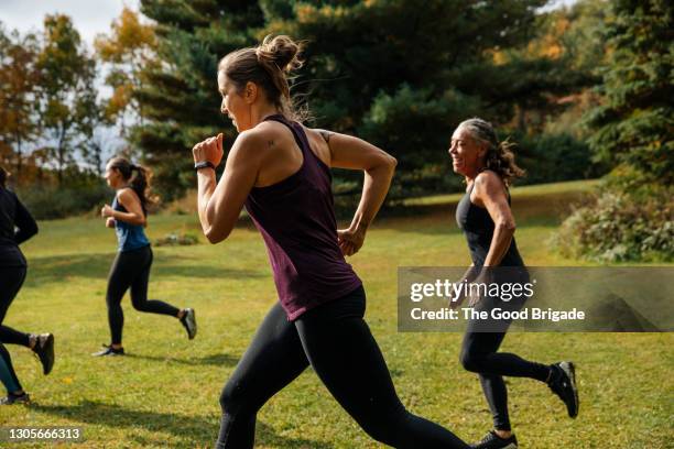 group of women running together at park - woman jogging stock pictures, royalty-free photos & images