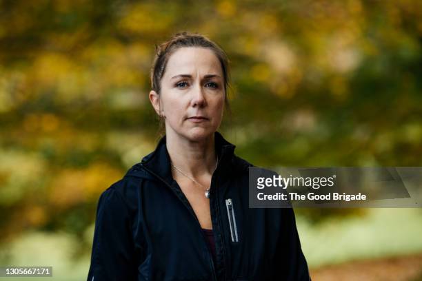 portrait of confident mature woman standing outdoors - トレーニングウェア ストックフォトと画像