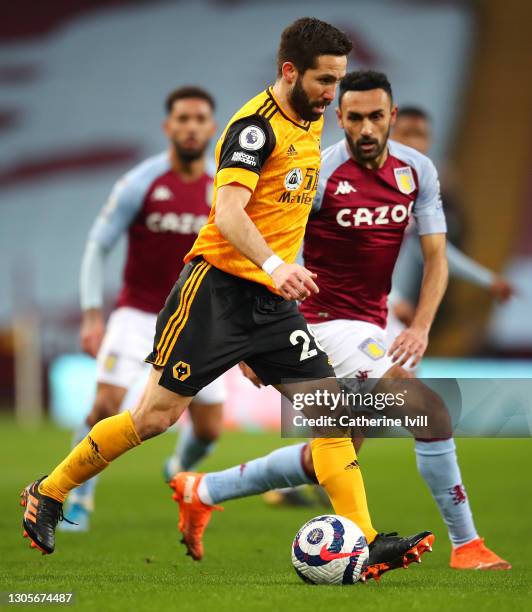 Joao Moutinho of Wolverhampton Wanderers is challenged by Ahmed El Mohamady of Aston Villa during the Premier League match between Aston Villa and...