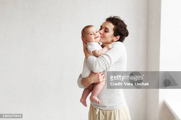 woman with baby on white background - bebé foto e immagini stock