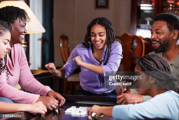 afroamerikanische familie zu hause spielen dominosteine - spieleabend stock-fotos und bilder