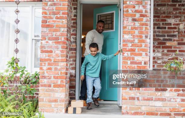 boy helps father get boxes delivered, left on doorstep - family front door imagens e fotografias de stock