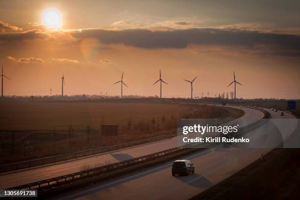 autobahn at sunset with wind turbines in the background, saxony, germany - deutsche autobahn stock-fotos und bilder