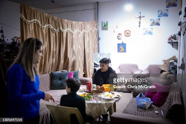Year old, Eisa Qais Hadi and his sister Maryam Qais Hadi , and brother Yousef who fled Qaraqosh in 2014, eat dinner in their temporary house which...