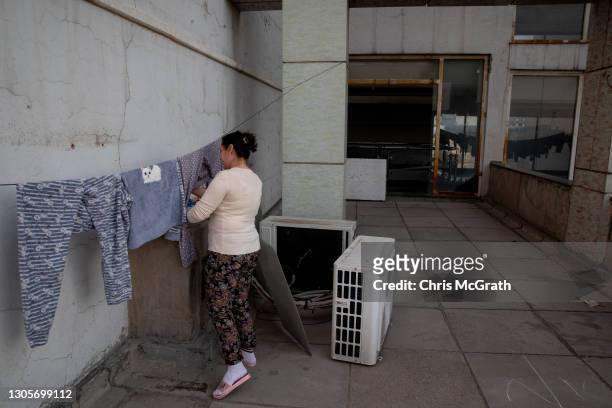 Rawaa Matti Polic, who fled her home in Bartella in 2014, hangs her washing on a balcony outside her temporary home on the empty fourth floor of a...