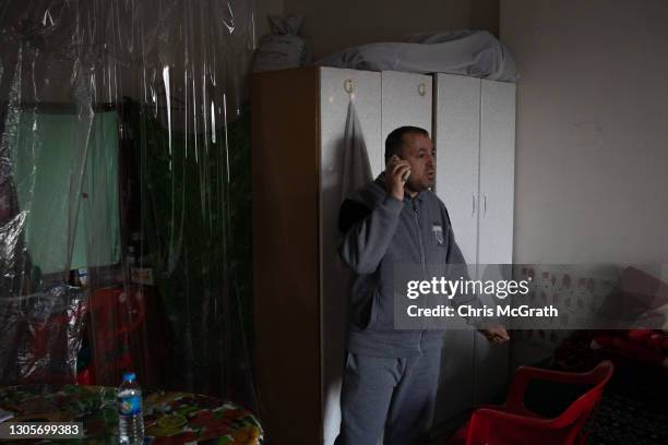 Ryadh Noail Jjlias who fled his home in Qaraqosh in 2014, talks on the phone in his temporary home on the empty fifth floor of a shopping mall on...