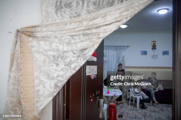 Friends and family members who fled their homes in Bartella in 2014, gather at Rawaa Matti Polic temporary home on the fourth floor of an empty...