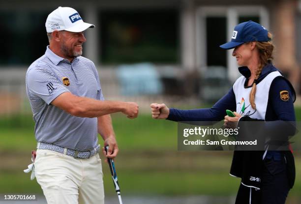 Lee Westwood of England celebrates with caddie Helen Story after making a putt for eagle on the 16th hole during the third round of the Arnold Palmer...