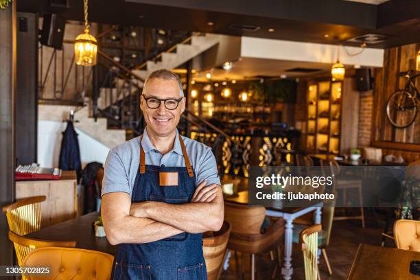 bartender wearing apron and smiling - small restaurant stock pictures, royalty-free photos & images