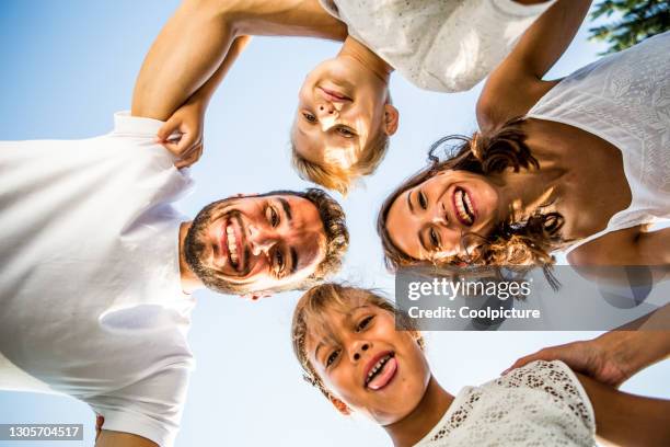 happy family with children smiling in a huddle - father sun stock pictures, royalty-free photos & images