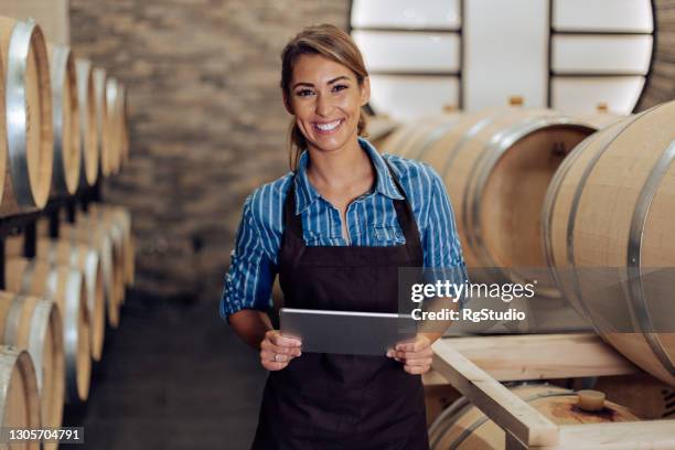 portrait of a happy, successful female entrepreneur working at her winery - tablet alcohol stock pictures, royalty-free photos & images