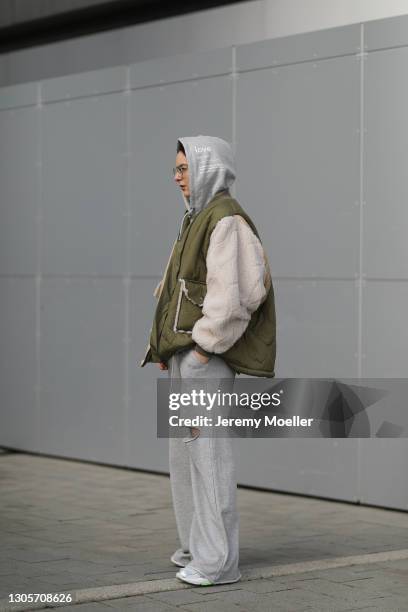 Maria Barteczko wearing green padded oversized The Frankie Shop jacket, grey printed JULOVE hoodie, grey Bershka jogging pants, white green New...