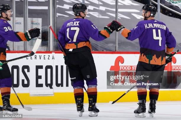 Niklas Hjalmarsson, Tyler Pitlick and Christian Fischer of the Arizona Coyotes celebrate after Pitlick scored an empty-net goal against the Minnesota...