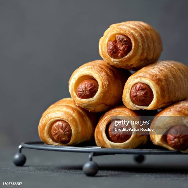 hot dogs snack on gray background, close up. pyramid of freshly baked sausage in puff pastry. food concept. copy space at left side. square format or 1x1 for posting on social media - puff pastry stock pictures, royalty-free photos & images